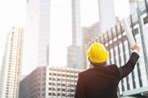 Close up engineers working on a building site holding a blueprints photo