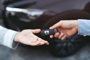 Professional salesperson Giving keys to new car owner.car rental. car insurance at dealership, women during work with customer at car dealership. photo