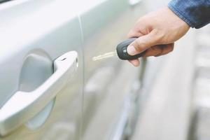 Car key, businessman handing over gives the car key to the other woman on car background. photo