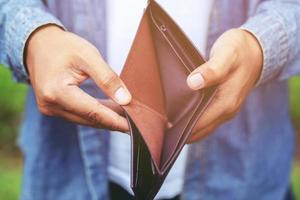 hombre de negocios que sostiene una billetera en manos de un hombre saca dinero de su bolsillo. foto