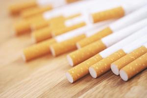 imagen de varios cigarrillos fabricados comercialmente. pila pila de cigarrillos en madera. o concepto de campaña para no fumadores, tabaco foto