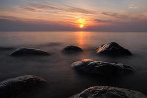 piedras en la costa del mar Báltico al atardecer foto