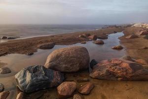 piedras en la costa del mar Báltico al atardecer foto