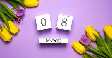 Women's day flat lay. 8 march calendar near a bunch of flowers photo