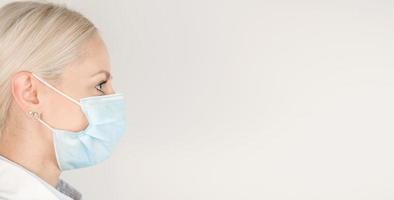 Side view on medical worker in a mask against white background. Healthcare banner with place for text. Covid-19 photo