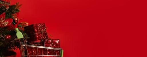 Winter Banner.Christmas or new year shopping concept. Cart with presents near christmas tree with place for text. Mock up photo