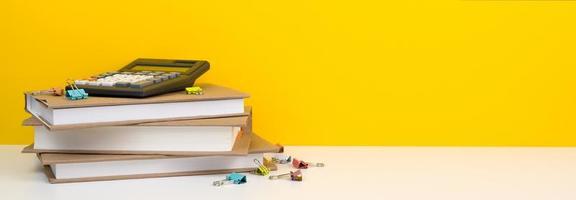 Calculator on top of pile of books. Financial literacy or economics classes cocnept photo