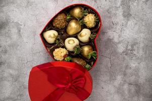 Top view on Heart shaped box with assorted chocolate covered strawberries on a gray background.St Valentine's.Vertical shot photo