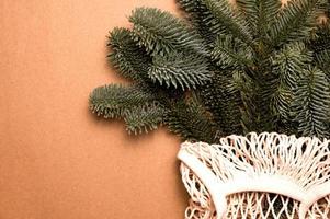 Closeup of fir tree brances in eco-friendly bag. Sustainable and aero waste winter holidays concept.Place for text photo