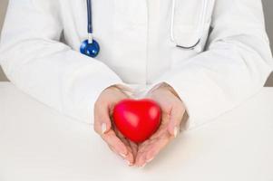 vista superior del corazón en manos del médico o de la enfermera. donación de órganos o concepto de caridad foto