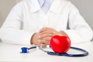 Closeup of heart near stethoscope on doctor's table. Heart diseases or organ donations concept photo
