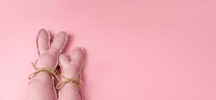 Monochrome pink easter banner with toy bunnies. Place for text photo