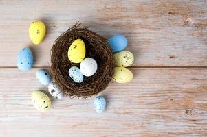 Top view on white,yellow and blue eggs in th nest Happy easter banner.Banner with place for text photo