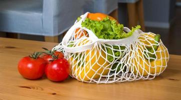 Fresh ripe vegetables in string bag with heart near. Zero waste. Harvest.Healthy eating.Diet. Sustainable shopping photo