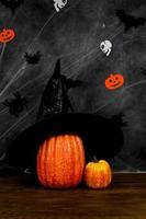 Vertical halloween banner with pumpkin with witch hat against dark background. Banner in balck and orange colors.