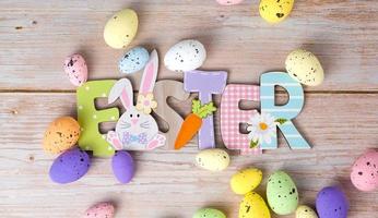 Easter flat lay banner with wooden sign near colorful eggs. Greetings card photo