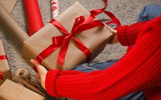 Closeup of woman hands holding gift in carft . Wrapping gifts and preparing for christmas photo