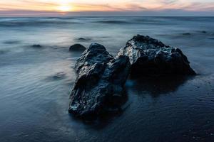 piedras en la costa del mar Báltico al atardecer foto