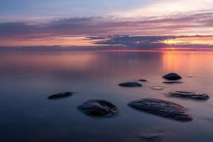 piedras en la costa del mar Báltico al atardecer foto