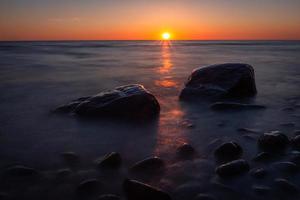 piedras en la costa del mar Báltico al atardecer foto