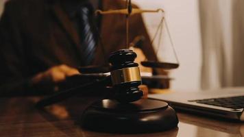 Justice and law concept.Male judge in a courtroom with the gavel, working with, computer and docking keyboard, eyeglasses, on table in morning light video