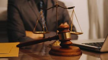 Justice and law concept.Male judge in a courtroom with the gavel, working with, computer and docking keyboard, eyeglasses, on table in morning light video