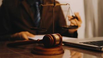 Justice and law concept.Male judge in a courtroom with the gavel, working with, computer and docking keyboard, eyeglasses, on table in morning light video