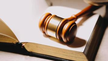 Justice and law concept.Male judge in a courtroom with the gavel, working with, computer and docking keyboard, eyeglasses, on table in morning light video