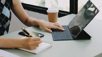 Geschäftsmann, der mit Smartphone und Laptop und digitalem Tablet-Computer im Büro mit digitalem Marketing arbeitet video