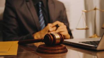 Justice and law concept.Male judge in a courtroom with the gavel, working with, computer and docking keyboard, eyeglasses, on table in morning light video