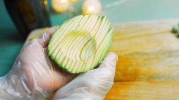 je tiens dans mes mains un avocat coupé en formes droites. prise de vue macro video