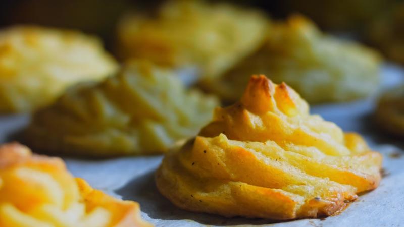 der koch macht kartoffelplätzchen mit einer lebensmitteltüte ...