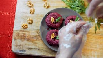 The girl tastes pkhali. Pkhali traditional Georgian food. Beetroot is used for the purple color. Walnut is used for decoration video