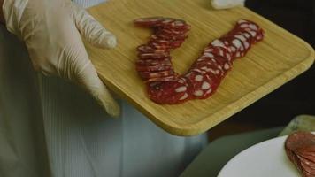 charcutaria plana com salame, diferentes tipos de queijo. tem frutas secas, nozes diversas e mel. arranjo de férias com velas acesas video