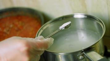 mengen allemaal ingrediënten met een houten lepel. koken Chili con carne, Mexicaans keuken video