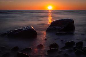 piedras en la costa del mar Báltico al atardecer foto