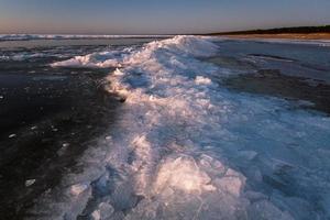 Baltic Sea Coast With Pebbles And Ice at Sunset photo