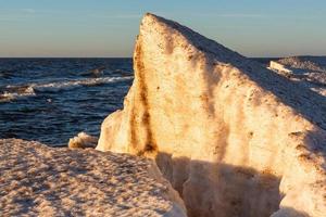 Baltic Sea Coast With Pebbles And Ice at Sunset photo