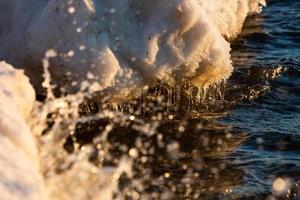 costa del mar báltico con guijarros y hielo al atardecer foto