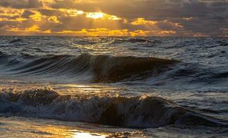 costa del mar báltico con guijarros y hielo al atardecer foto