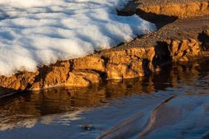 costa del mar báltico con guijarros y hielo al atardecer foto