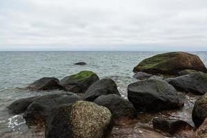 costa del mar báltico con guijarros y hielo al atardecer foto