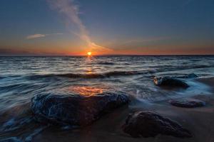 piedras en la costa del mar Báltico al atardecer foto