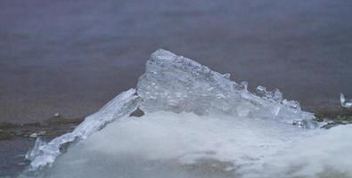 costa del mar báltico con guijarros y hielo al atardecer foto