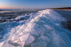 Baltic Sea Coast With Pebbles And Ice at Sunset photo