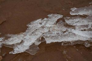 costa del mar báltico con guijarros y hielo al atardecer foto