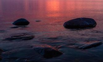 piedras en la costa del mar Báltico al atardecer foto