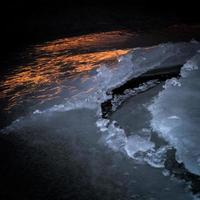 costa del mar báltico con guijarros y hielo al atardecer foto