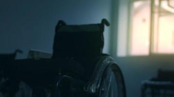 sida se av ett amerikan manlig arbetare i en verkstad på en fabrik framställning rullstolar, Sammanträde på en arbetsbänk använder sig av hand verktyg och montering delar av en produkt, Sammanträde i rullstolar video