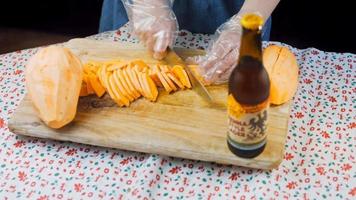 The chef cuts the sweet potatoes into slices. Romantic atmosphere in the background video